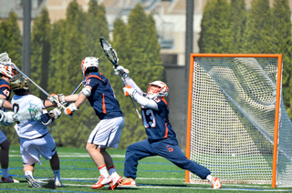 Evan Molloy reaches his stick high, attempting to make a save. He had seven on the day. 